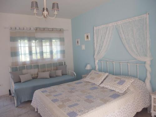 a blue bedroom with a bed and a window at Christos Studios in Zóla