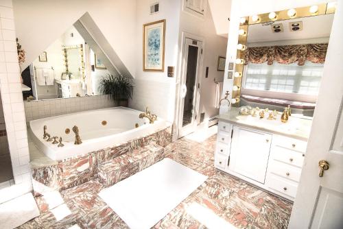 a bathroom with a tub and a sink and a mirror at Stafford House Bed & Breakfast in Fairfax