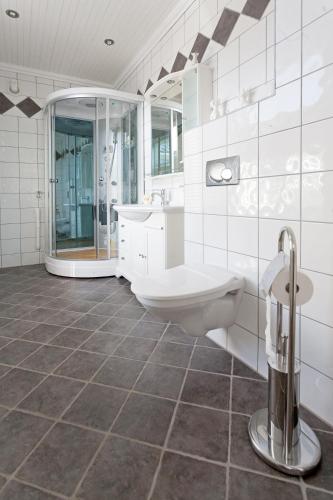 a white bathroom with a toilet and a sink at Sakrisøy Gjestegård - Manor House in Sakrisøy - Solbakken anno 1880 in Reine