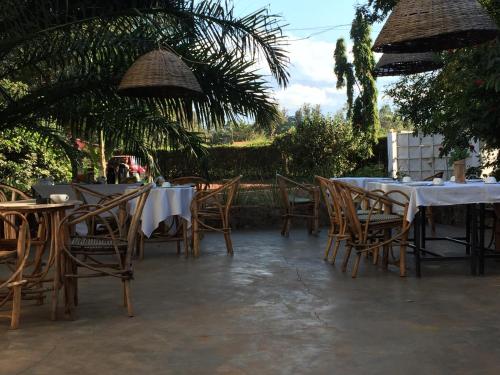 a patio with tables and chairs and umbrellas at More Than A Drop in Moshi