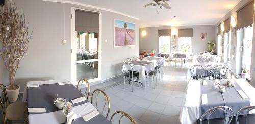 a restaurant with tables and chairs in a room at Zajazd u Sosny in Torzym