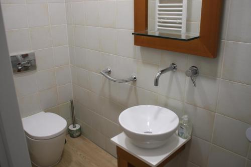 a bathroom with a sink and a toilet and a mirror at Hostel Sopot Centrum in Sopot