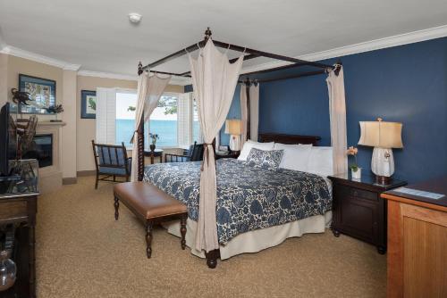 a bedroom with a canopy bed and a desk and chair at Blue Dolphin Inn in Cambria