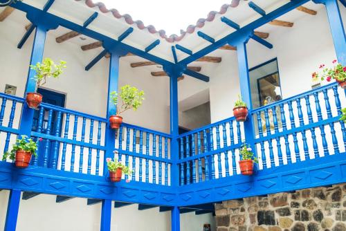 a blue balcony with potted plants on it at Rumi Wasi in Cusco