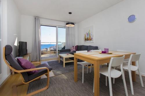 ein Wohnzimmer mit einem Tisch und Stühlen sowie ein Esszimmer in der Unterkunft Apartments Zorka in Primošten