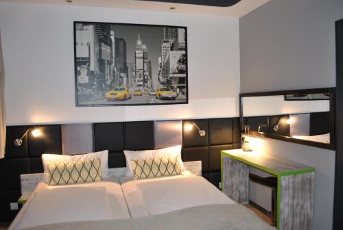 a bedroom with a white bed and a black and white picture at Landmark am Kracauerplatz in Berlin