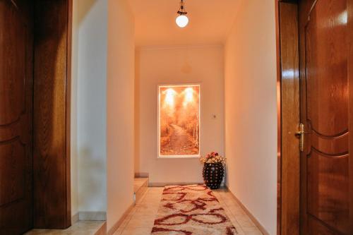 a hallway with a painting and a vase of flowers at Gold Hotel in Korçë