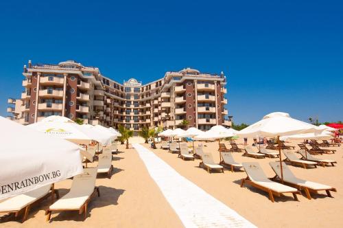 eine Reihe von Stühlen und Sonnenschirmen am Strand in der Unterkunft Golden Rainbow Beach Hotel in Sonnenstrand