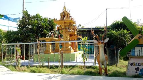 a statue of a deer standing in front of a temple at RuengsriSiri Guesthouse in Sukhothai