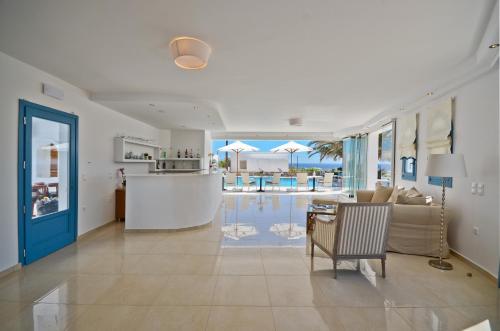 a living room with a view of a pool at Dilino Hotel Studios in Agios Prokopios