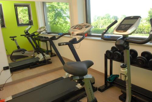 a gym with three exercise bikes in a room at Hotel Gardenia in Romano Canavese