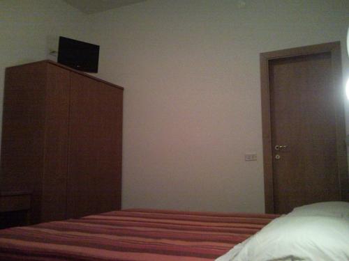 リミニにあるHotel Trinidadのベッドルーム1室(ベッド1台、ドレッサー、テレビ付)