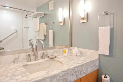 a bathroom with a sink and a mirror at Ala Moana Honolulu by Mantra in Honolulu