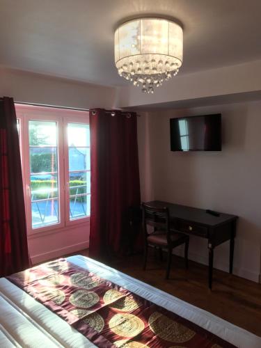 a bedroom with a bed and a table and a chandelier at L'hostellerie de Sèvremont in Saint-Michel-Mont-Mercure