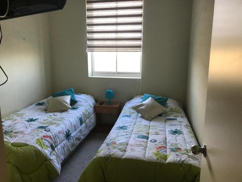 una camera da letto con due letti e una finestra di Algarrobo, Laguna bahí­a departamento 1303 & 302 ad Algarrobo