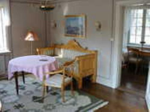 a living room with a table and a piano at Forsbacka Wärdshus in Forsbacka