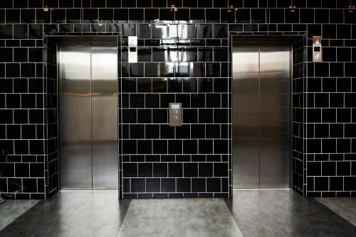 a urinal in a public restroom at Essence Hotel Carlton in Melbourne
