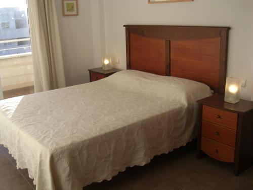 1 dormitorio con 1 cama y 2 mesitas de noche con velas en Golf y playa junto al Cabo de Gata en Almería