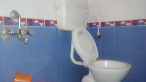 uma casa de banho com um WC branco num quarto azul em Central Mina Residency- only for Indians em Chennai