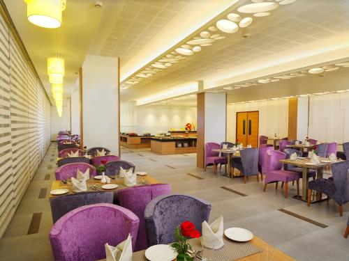 a dining room with purple chairs and tables at The Central Residency in Trivandrum