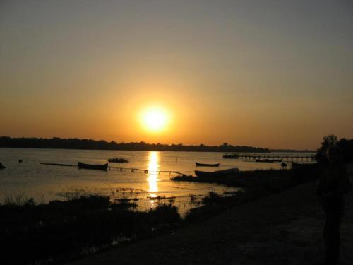 a sunset over a river with boats in the water at Casa de vacanta Spiritul Deltei in Sfântu Gheorghe