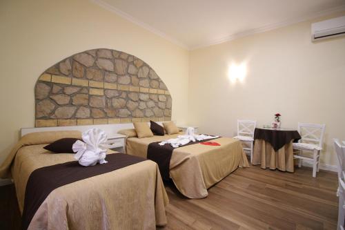 a room with two beds and a stone wall at Freedom Love B&B in Rome
