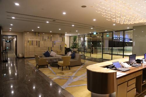 a lobby with a reception counter with laptops on it at Ambassador Transit Hotel - Terminal 2 in Singapore