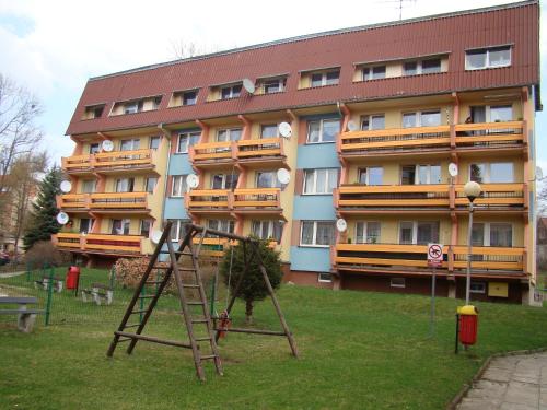 a playground in front of a large building at Apartament Nina in Szklarska Poręba