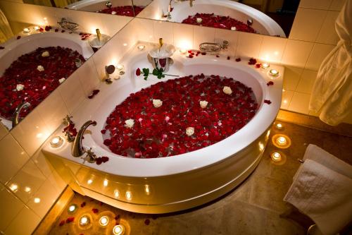 a large tub full of red flowers in a bathroom at Villa Ammende Restaurant and Hotel in Pärnu