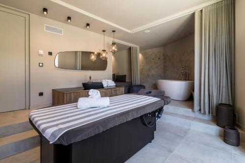 a bedroom with a large bed and a bath tub at Hotel Seehof Nature Retreat in Naz-Sciaves