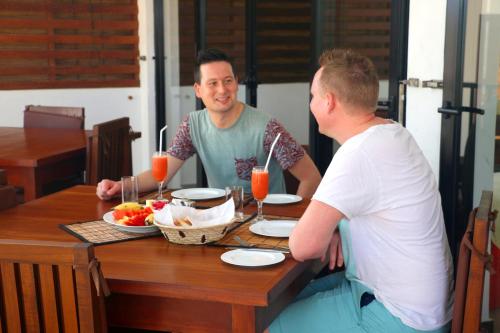 a man and a woman sitting at a table with food at Wellé Wadiya Beach Villa in Kalpitiya