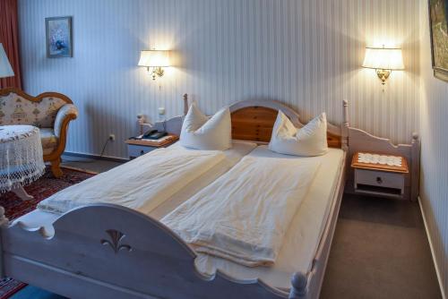 a bedroom with a large white bed with pillows at Landhotel Schnupp in Neudrossenfeld