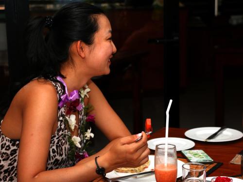 a woman sitting at a table eating food at Wellé Wadiya Beach Villa in Kalpitiya