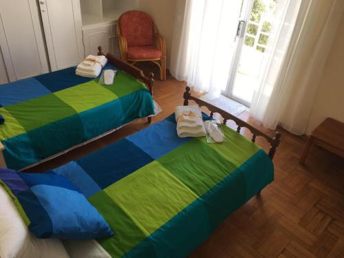 マルコポウロンにあるApartment in Markopoulo centerのベッドルーム1室(ベッド2台、椅子、窓付)