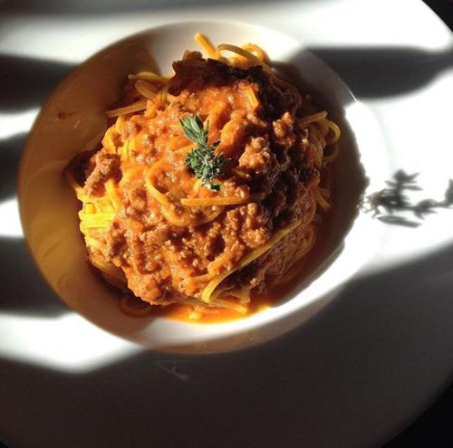 a white bowl of pasta with meat and sauce at Il Vigneto in Roddi