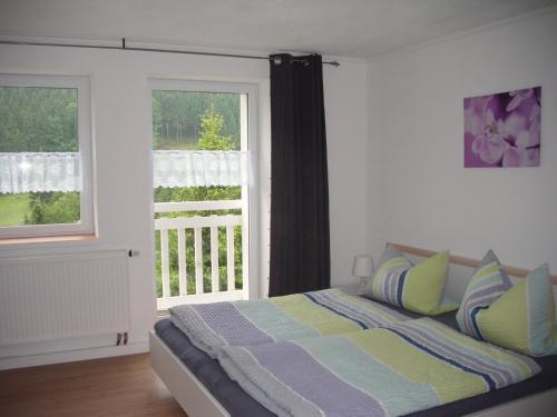 a bedroom with a bed and a large window at Greizer Kammhütte Gaststätte & Pension in Klingenthal