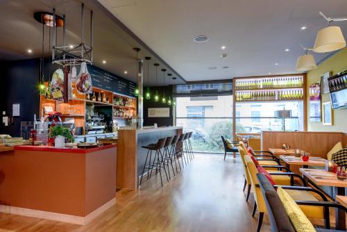 a restaurant with a bar and tables and chairs at Mercure Hotel Mannheim am Rathaus in Mannheim