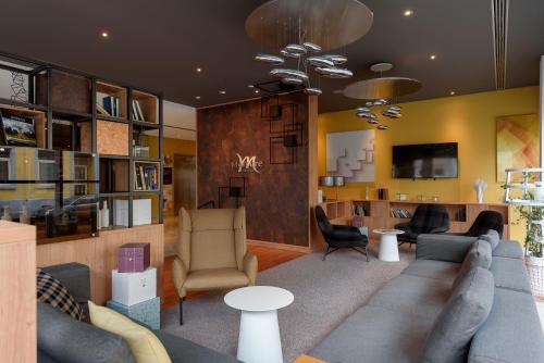 a living room with a couch and chairs at Mercure Hotel Mannheim am Rathaus in Mannheim