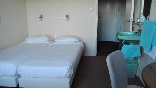 a hotel room with a bed and a sink at Pension de Zeeschelp in Domburg