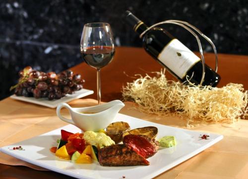 une table avec une assiette de nourriture et un verre de vin dans l'établissement Sea Sun Cocoon, à La Rochelle