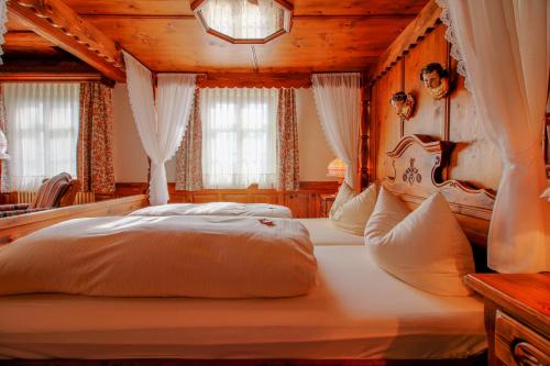 a large bed in a room with wooden ceilings at Landhotel Schnupp in Neudrossenfeld