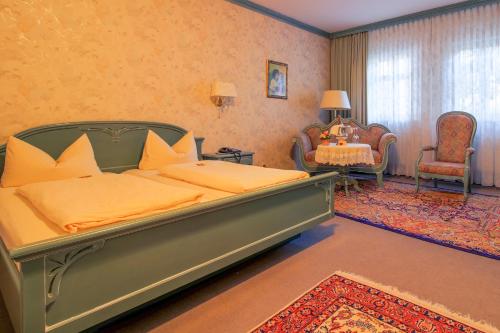 a bedroom with a large bed and a table and chairs at Landhotel Schnupp in Neudrossenfeld