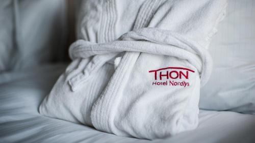 a white towel with a sign on it on a bed at Thon Hotel Nordlys in Bodø