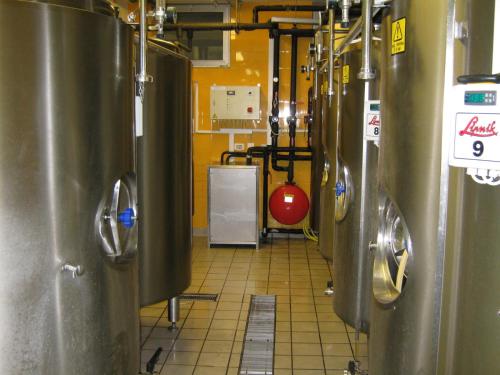 a row of silver tanks in a kitchen with ailed floor at Hotel Prunk in Sežana