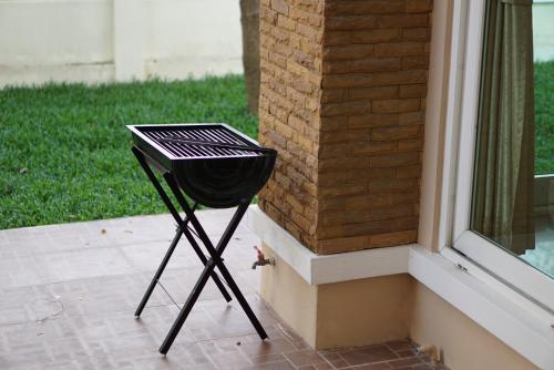 a grill sitting on a porch next to a window at Villa at Casalunar Bangsaen in Bangsaen