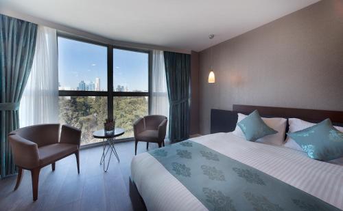イスタンブールにあるThe Clock Suitesのベッドと大きな窓が備わるホテルルームです。
