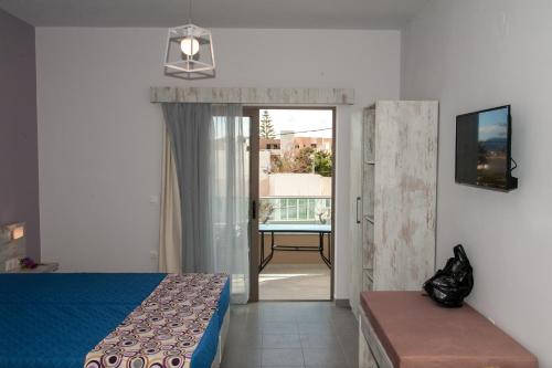 sypialnia z łóżkiem i drzwiami prowadzącymi na balkon w obiekcie Efrilias Studios & Apartments w mieście Kisamos