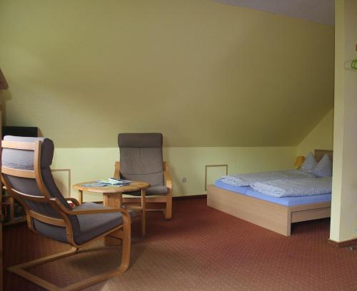 a bedroom with a bed and a chair and a table at Fewo's Kiekut in Lohme