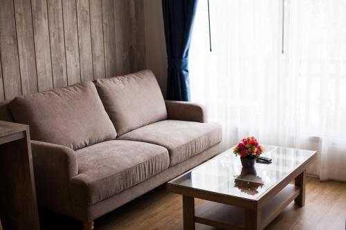 a living room with a couch and a coffee table at Anchan Laguna Hotel โรงแรมอัญชันลากูน่า in Khon Kaen