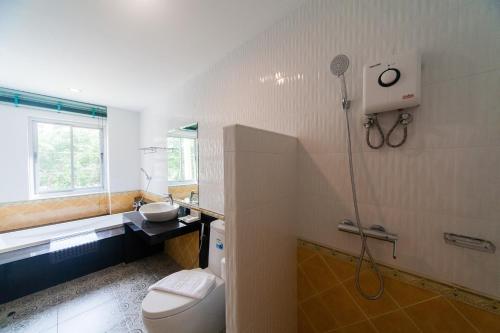 a bathroom with a toilet and a sink and a shower at Anchan Laguna Hotel โรงแรมอัญชันลากูน่า in Khon Kaen